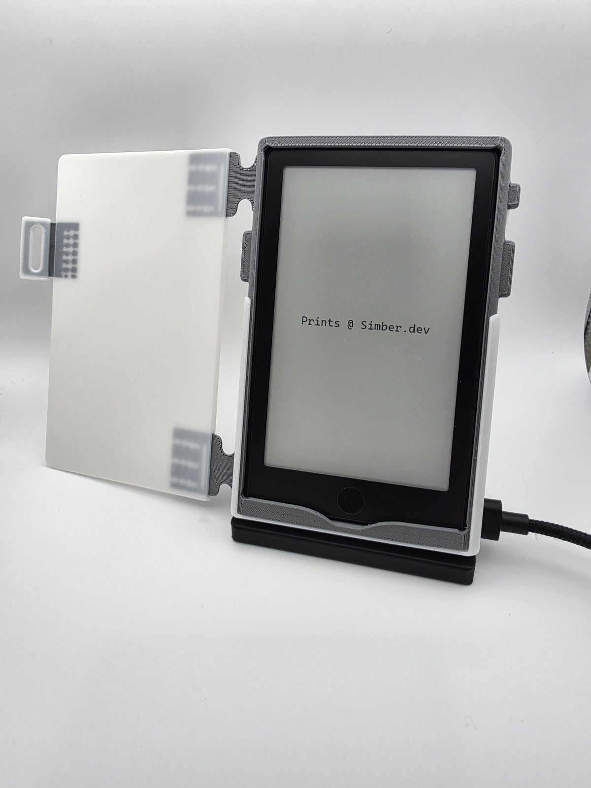 A white folio case, opened, resting on black charging stand.