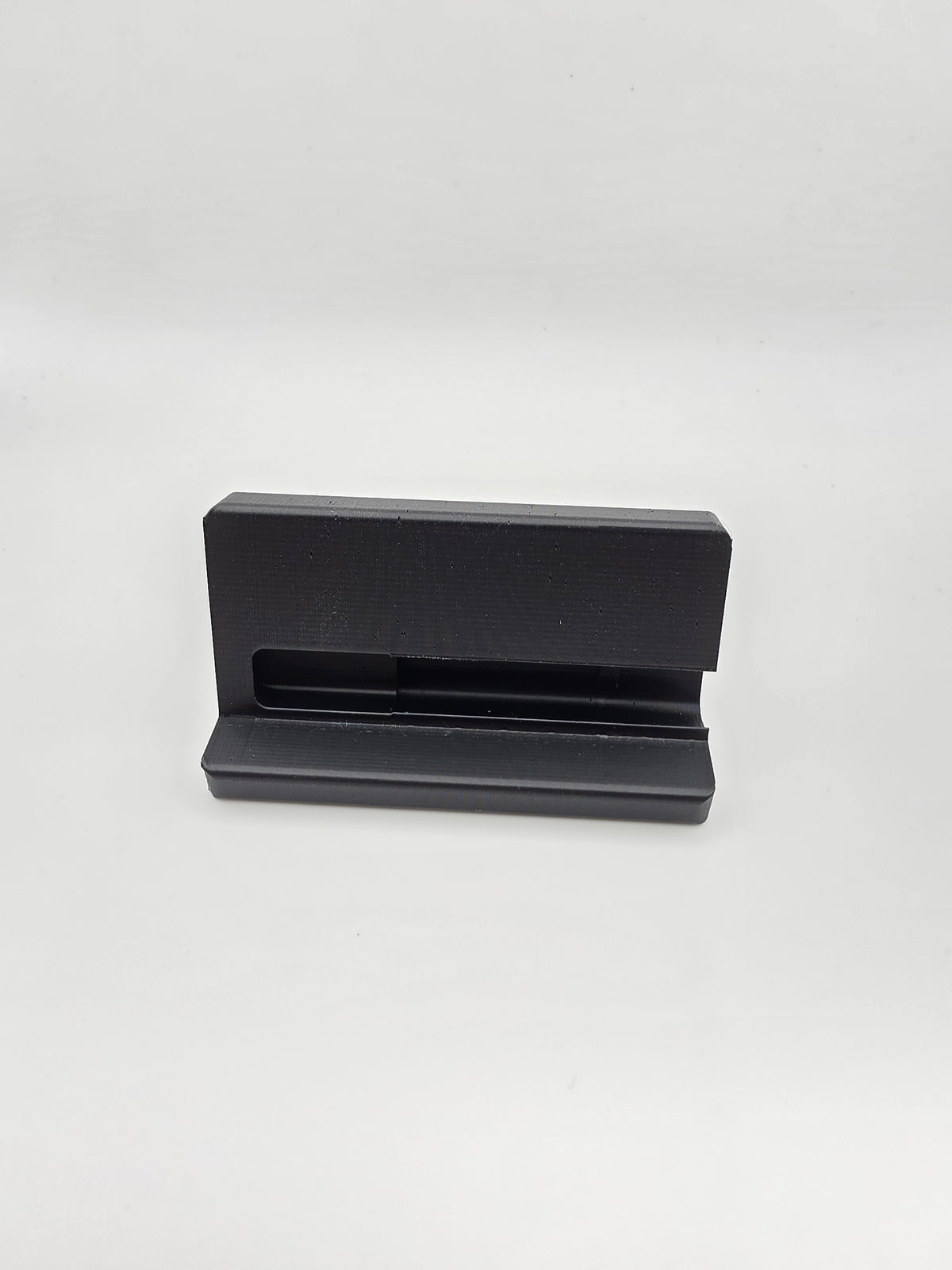 A black and gray 3D-printed phone dock or stand, front view.