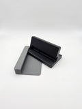 A black and gray 3D-printed stand, with the optional case-less device spacer attachment