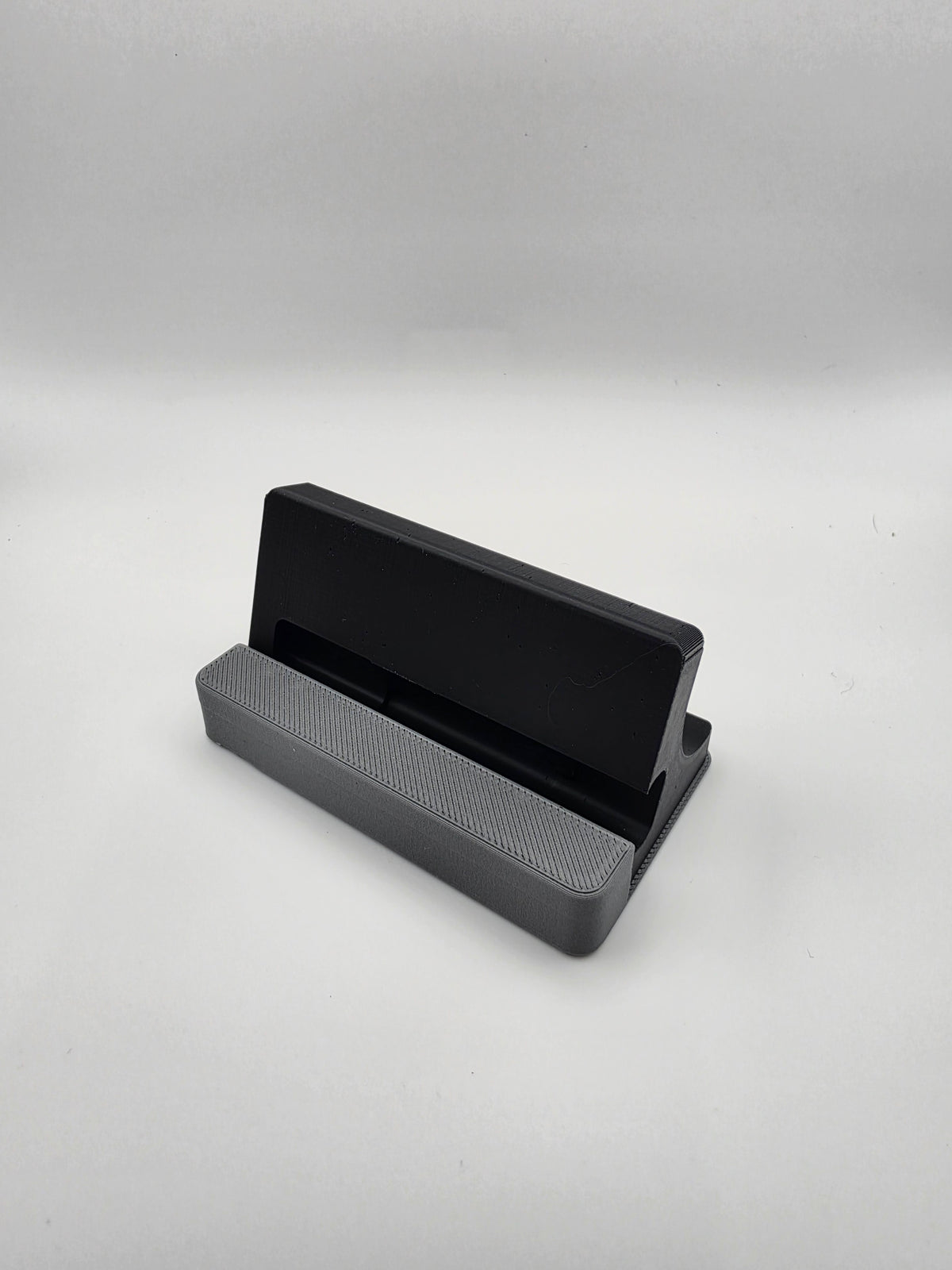 A black and gray 3D-printed  stand, shown from a three-quarters perspective on a light gray background.